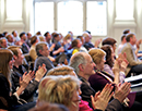 Link zur Seite „Berlin 12/2013“ (Eine Gruppe applaudierender Menschen in einem Hörsaal)