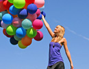 Link zur Seite „www.praktisch-unschlagbar.de“ (Junge Frau mit bunten Luftballons)