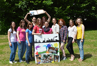 Die Schülerfirma farb-E mit ihrem Produkt - dem Mitmachbuch - und einem kreativen Plakat
