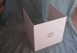 Eine weiße Box auf einem grauen Leinentuch