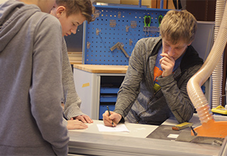 Drei Schüler der Schülerfirma "Leisebox" bei der Planung und Konzeption in der Werkstatt der Schülerfirma