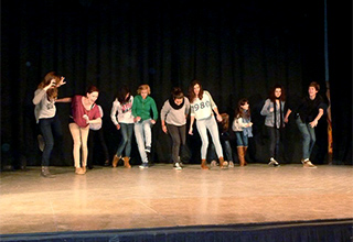 Schülerinnen der "Schülerfairma S-GmbH" auf einer Theaterbühne