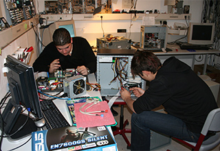 Zwei Schüler der Schülerfirma "TuN e.V." beim Bauen von PC-Hardware in ihrer Werkstatt