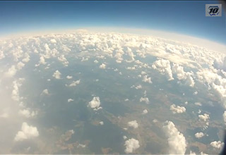 Blick auf die Erde und lockere Wolken aus circa 10000 Metern