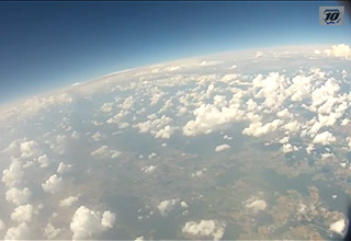 Blick auf die Erde und lockere Wolken aus circa 10000 Metern