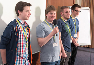 Das Team Nord Bank: vier Schüler auf einer Bühne halten Präsentation