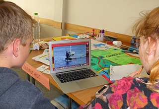 Zwei Teammitglieder von SurFüchse bei der Arbeit am Laptop
