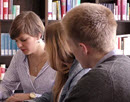 Link zur Seite „Video Entrepreneurship Education“ (Zwei Schüler und eine Schülerin sitzen am Schreibtisch in einer Bibliothek)
