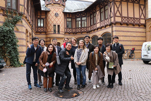 Gruppenbild des südkoreanischen Delegation mit Mitgliedern des Fachnetzwerks Schülerfirmen vor einem alten Gebäude
