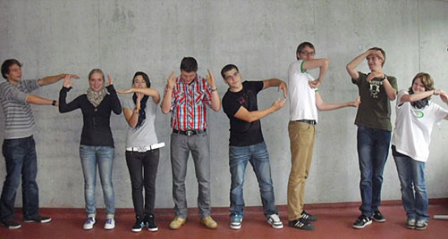 Schüler posieren vor einer grauen Wand