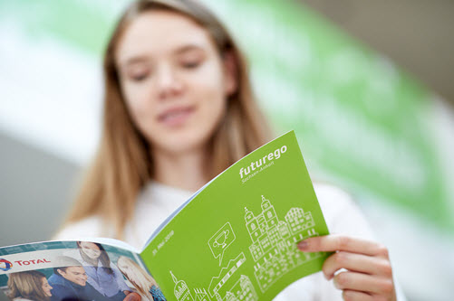 Schülerin hält Broschüre von futurego in ihren Händen und liest darin