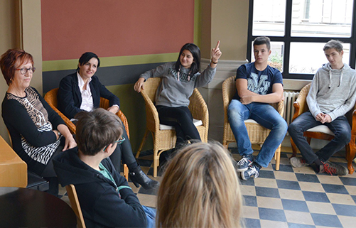 Schüler und Schülerinnen sitzen im Stuhlkreis bei Unternehmergespräch