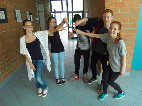 Schülerinnen und Schüler vom Burgendlandgymnasium in Laucha stehen in einem Schulflur im Halbkreis und lächeln