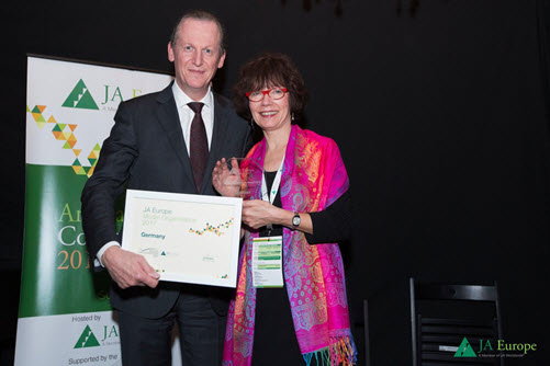 Die Geschäftsführerin der IW JUNIOR gGmbH, Marion Hüchtermann, nimmt die internationale Auszeichnung entgegen