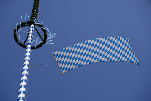 Maibaum in Blau-Weiß mit bayerischer Flagge