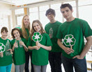 Lehrer mit Schülerinnen und Schülern alle im gleichen grünen T-Shirt